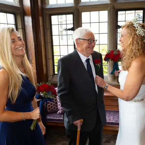Wedding photo of the brides father and bridesmaid laughing at Fanhams Hall, Ware, Hertfordshire.  – photography by Glen Smith