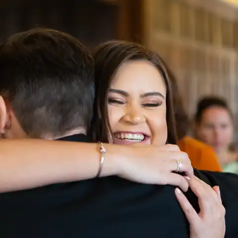 Wedding photo of the groom hugging a guest at Fanhams Hall, Ware, Hertfordshire.  – photography by Glen Smith