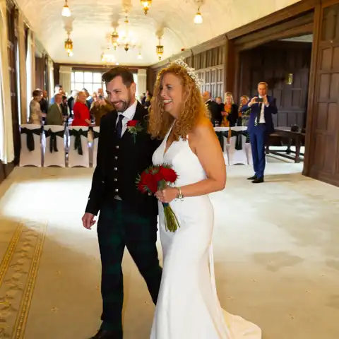 Wedding photo of the bride and groom walking down the aisle in the Long Gallery at Fanhams Hall, Ware, Hertfordshire.  – photography by Glen Smith