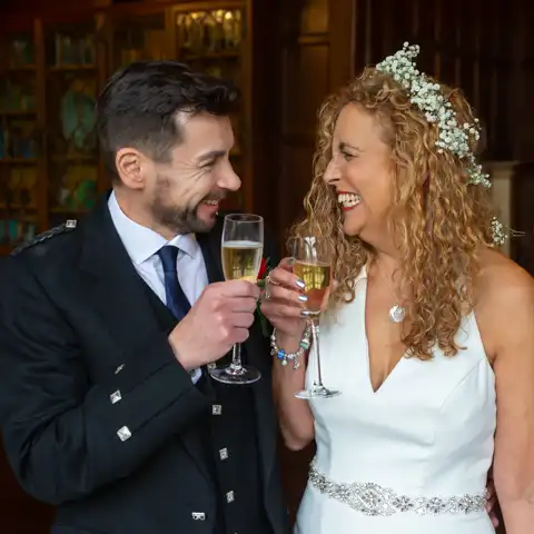 Wedding photo of the bride and groom toasting each other with champagne at Fanhams Hall, Ware, Hertfordshire.  – photography by Glen Smith