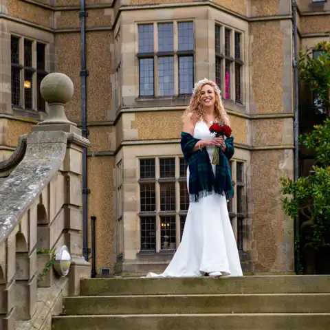Wedding photo of the bride on the steps outside Fanhams Hall at Fanhams Hall, Ware, Hertfordshire.  – photography by Glen Smith