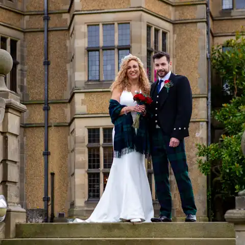 Wedding photo of the bride and groom on steps outside Fanhams Hall at Fanhams Hall, Ware, Hertfordshire.  – photography by Glen Smith