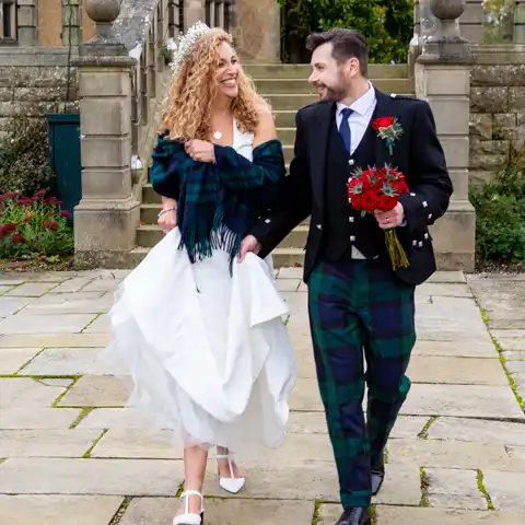 Wedding photo of the bride and groom with Fanhams Hall behind them at Fanhams Hall, Ware, Hertfordshire.  – photography by Glen Smith