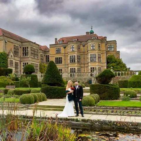 Wedding photo of the bride and groom walking outside Fanhams Hall at Fanhams Hall, Ware, Hertfordshire.  – photography by Glen Smith