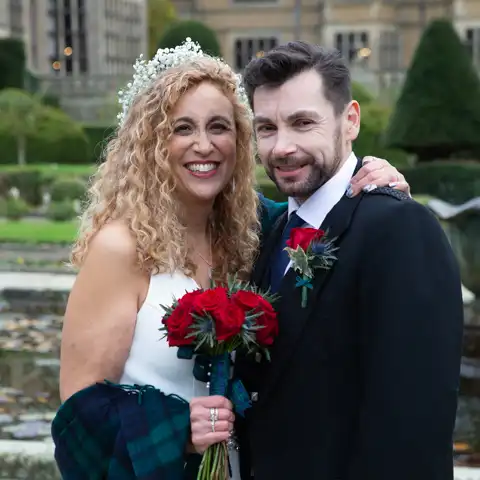 Wedding photo of the bride and groom with Fanhams Hall behind them at Fanhams Hall, Ware, Hertfordshire.  – photography by Glen Smith