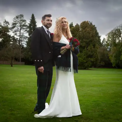 Wedding photo of the bride and groom with a dramatic sky behind them at Fanhams Hall, Ware, Hertfordshire.  – photography by Glen Smith