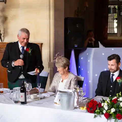 Wedding photo of the bride and groom laughing during the wedding speeches at Fanhams Hall, Ware, Hertfordshire.  – photography by Glen Smith