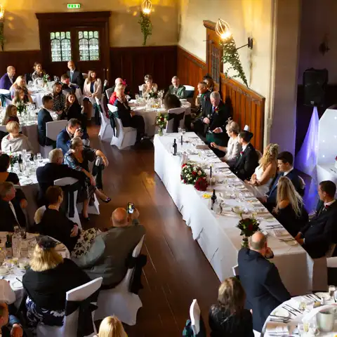 Wedding photo of an overhead view of the tables and guests during the wedding speeches at Fanhams Hall, Ware, Hertfordshire.  – photography by Glen Smith