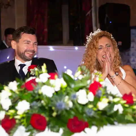 Wedding photo of the bride and groom laughing druing wedding speeches at Fanhams Hall, Ware, Hertfordshire.  – photography by Glen Smith