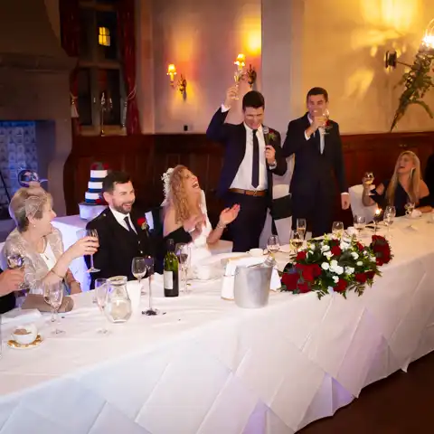 Wedding photo of the bride and groom laughing druing wedding speeches at Fanhams Hall, Ware, Hertfordshire.  – photography by Glen Smith